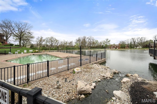 community pool with a water view and fence