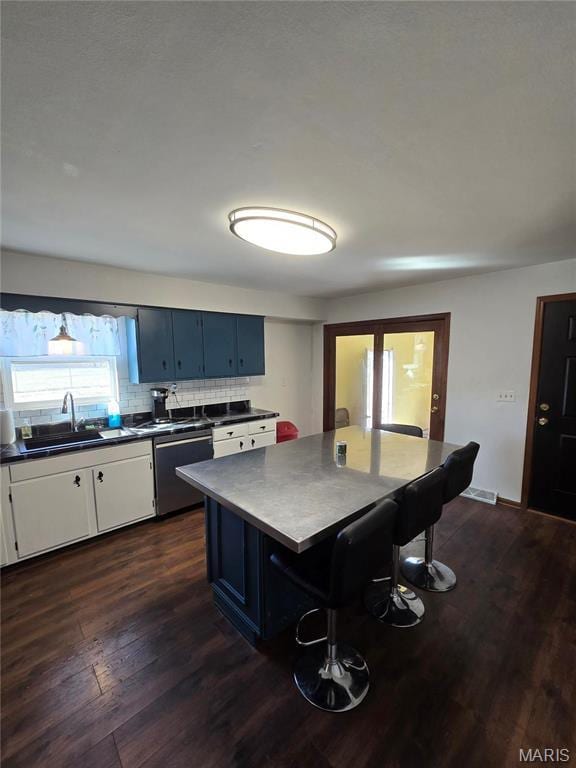 423 Virginia St, Granite City, IL 62040 - kitchen featuring a sink, stainless steel dishwasher, dark countertops, tasteful backsplash, and dark wood-type flooring