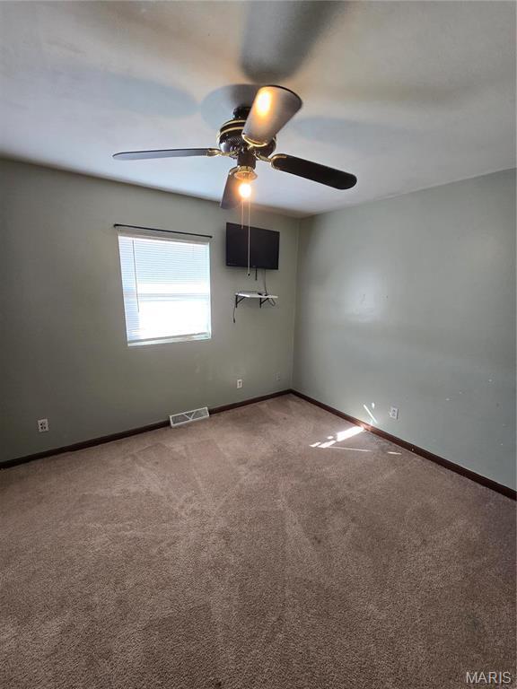 423 Virginia St, Granite City, IL 62040 - unfurnished room featuring carpet flooring, a ceiling fan, and baseboards