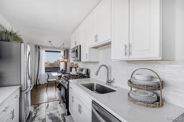 4466 W Pine Blvd Unit 8E, Saint Louis, MO 63108 - kitchen with stainless steel appliances, a sink, light countertops, and white cabinetry