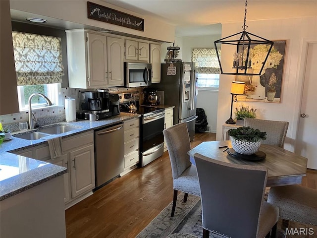 550 N 4th St, Breese, IL 62230 - kitchen with stainless steel appliances, a sink, a chandelier, stone counters, and dark wood-style floors