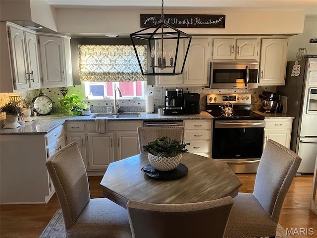 550 N 4th St, Breese, IL 62230 - kitchen with stainless steel appliances, a sink, a chandelier, and decorative backsplash