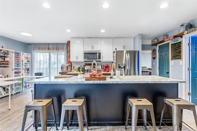 703 Locust St, Desloge, MO 63601 - kitchen featuring stainless steel appliances, white cabinetry, recessed lighting, a kitchen bar, and a spacious island
