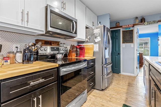 703 Locust St, Desloge, MO 63601 - kitchen with stainless steel appliances, white cabinets, decorative backsplash, light wood-style flooring, and butcher block countertops