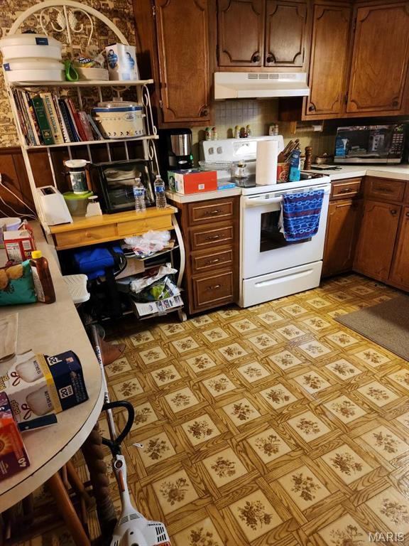 923 Dixie Ave, Fulton, MO 65251 - kitchen with electric stove, under cabinet range hood, light countertops, black microwave, and light floors