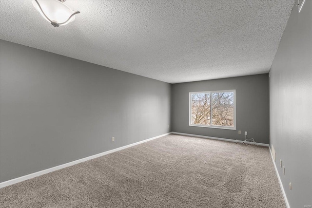 carpeted empty room with a textured ceiling and baseboards