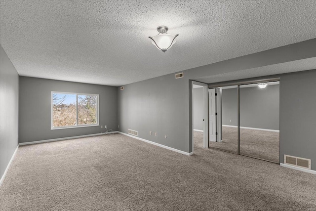 unfurnished bedroom with carpet, a textured ceiling, a closet, and baseboards