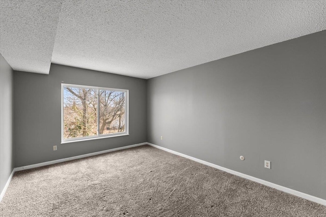 carpeted spare room with a textured ceiling and baseboards