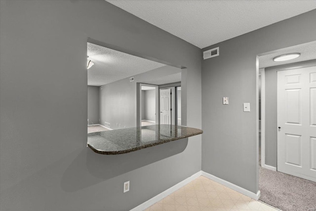 kitchen featuring a textured ceiling and baseboards
