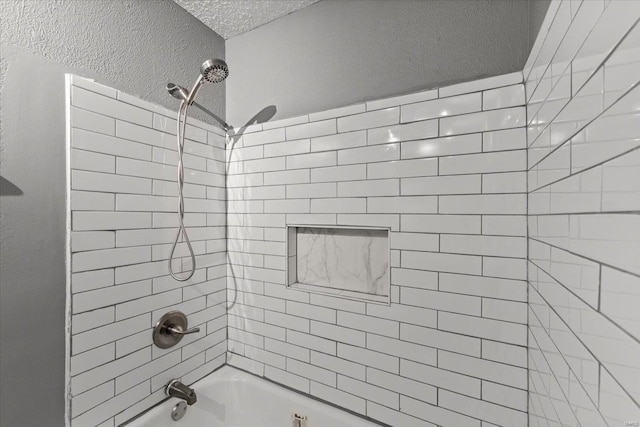 full bath featuring bathtub / shower combination, a textured ceiling, and a textured wall