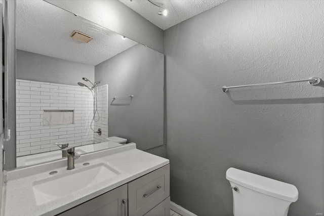 full bathroom with a textured ceiling, toilet, a shower, and vanity