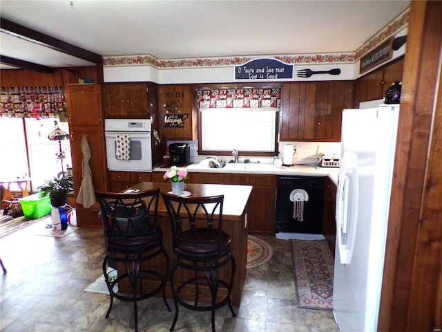 508 N Galloway Rd, Vandalia, MO 63382 - kitchen with white appliances, a sink, light countertops, a kitchen island, and dark brown cabinetry