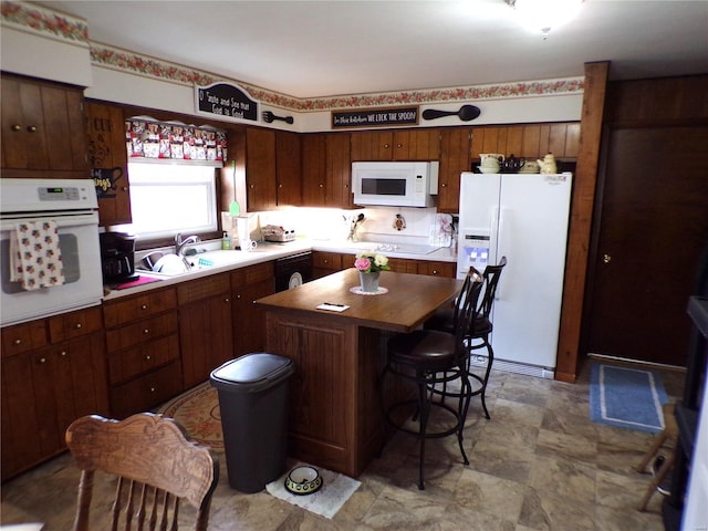 508 N Galloway Rd, Vandalia, MO 63382 - kitchen featuring white appliances, a center island, a sink, a kitchen breakfast bar, and wooden counters