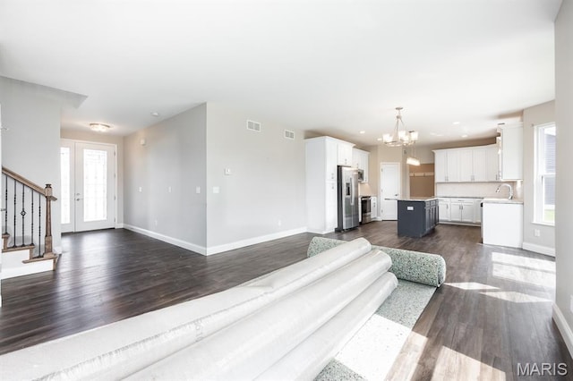 135 Reagan Dr, Troy, IL 62294 - unfurnished living room with a chandelier, stairs, dark wood-style floors, baseboards, and recessed lighting