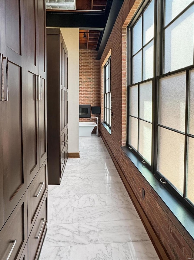 6 E Front St Unit 6, Washington, MO 63090 - hallway featuring light marble finish floors, brick wall, and baseboards
