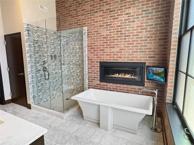 6 E Front St Unit 6, Washington, MO 63090 - full bath featuring a stall shower, a soaking tub, and a glass covered fireplace