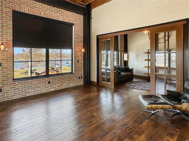 6 E Front St Unit 6, Washington, MO 63090 - living area featuring french doors, wood-type flooring, beamed ceiling, brick wall, and baseboards