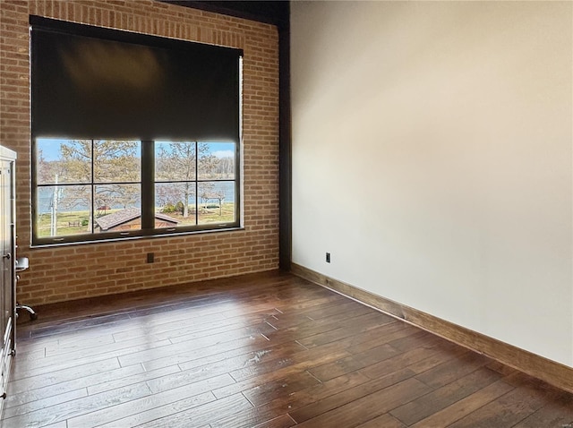 6 E Front St Unit 6, Washington, MO 63090 - spare room featuring dark wood-style floors, baseboards, and brick wall