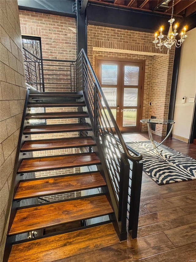 6 E Front St Unit 6, Washington, MO 63090 - staircase featuring hardwood / wood-style floors, a chandelier, brick wall, and french doors