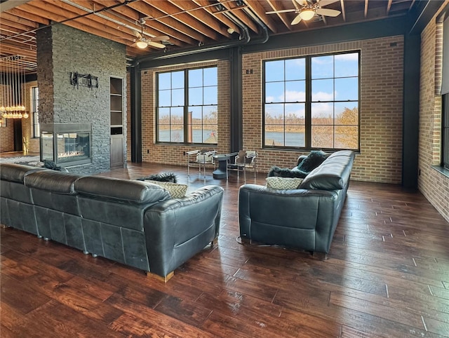 6 E Front St Unit 6, Washington, MO 63090 - living area featuring brick wall, ceiling fan, hardwood / wood-style floors, a stone fireplace, and beam ceiling