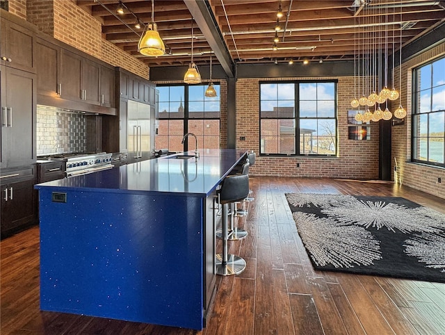 6 E Front St Unit 6, Washington, MO 63090 - kitchen featuring brick wall, premium appliances, a sink, dark wood finished floors, and rail lighting