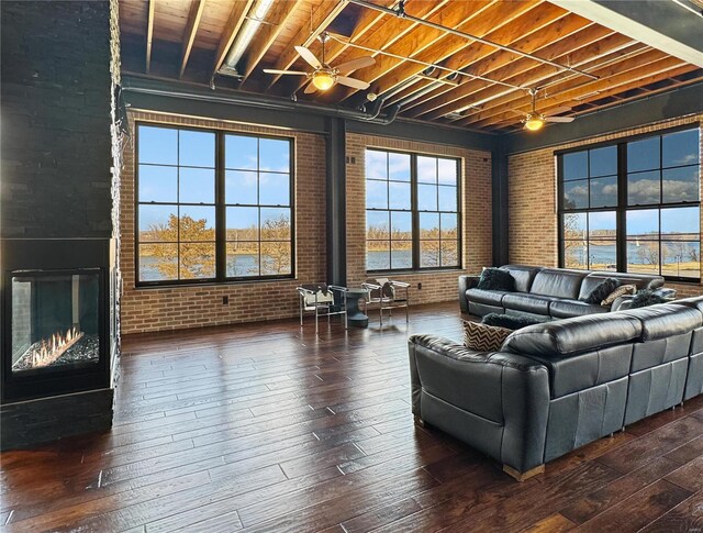 6 E Front St Unit 6, Washington, MO 63090 - living room with brick wall, a ceiling fan, hardwood / wood-style floors, a wood stove, and beamed ceiling