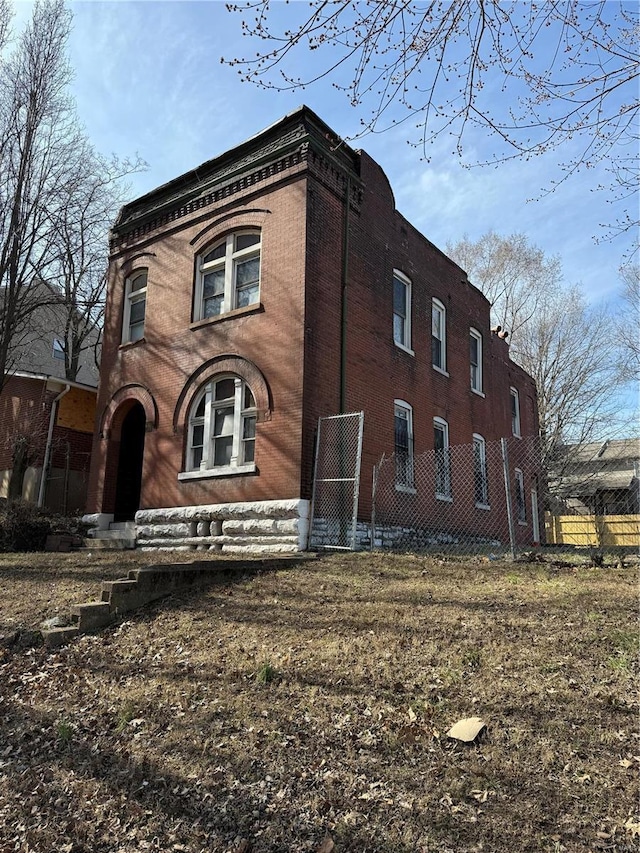 view of side of home with fence and brick siding
