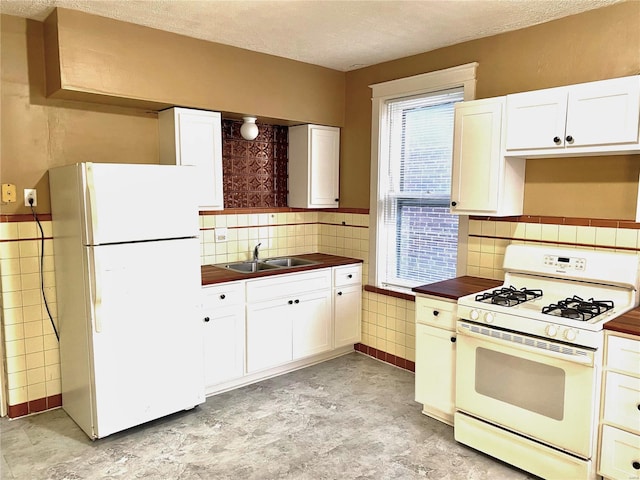 5727 Dewey Ave, Saint Louis, MO 63116 - kitchen featuring white appliances, a sink, a textured ceiling, white cabinetry, and backsplash