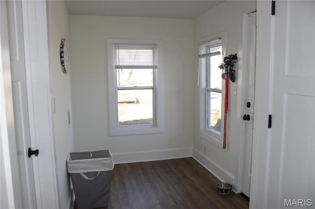 spare room featuring dark wood-style floors and baseboards