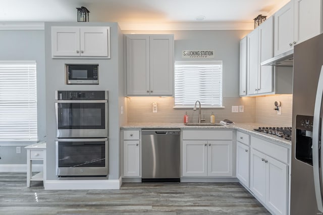 24345 State Rte Ww Unit 46, Saint Genevieve, MO 63670 - kitchen with stainless steel appliances, crown molding, tasteful backsplash, a sink, and light wood-style floors
