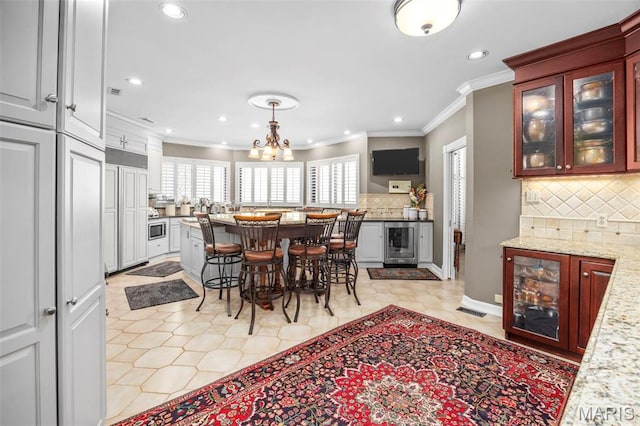 651 Kiefer Creek Rd, Ballwin, MO 63021 - dining room featuring wine cooler, ornamental molding, recessed lighting, light tile patterned floors, and a chandelier