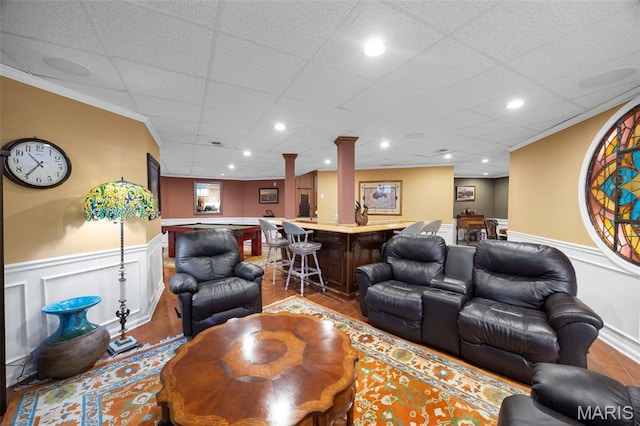 651 Kiefer Creek Rd, Ballwin, MO 63021 - living area with bar with sink, wainscoting, wood finished floors, a decorative wall, and ornamental molding