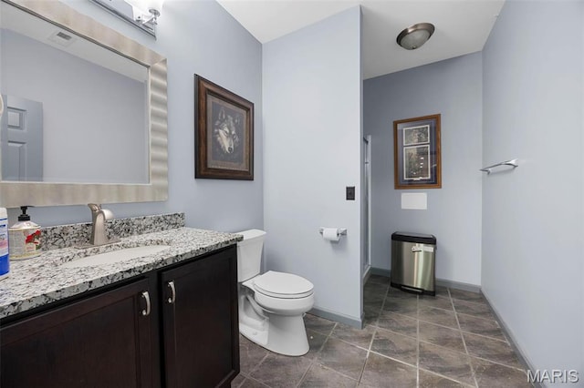 651 Kiefer Creek Rd, Ballwin, MO 63021 - bathroom featuring baseboards, toilet, vanity, a shower, and stone finish floors