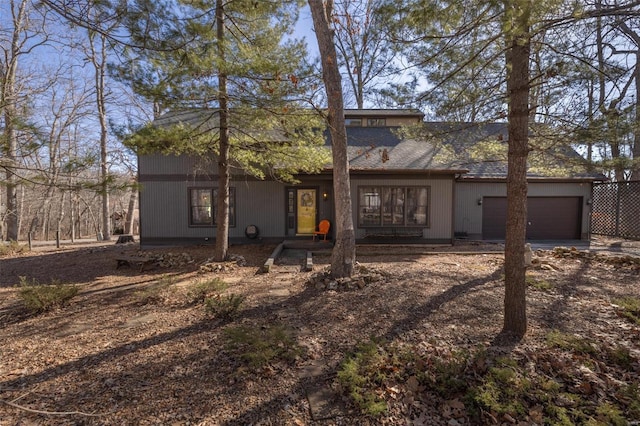 back of house with a garage and dirt driveway