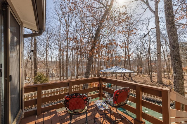 wooden terrace with view of wooded area