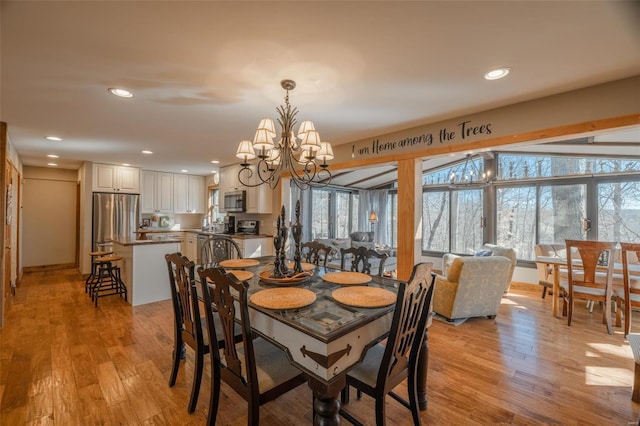 dining space with a chandelier, light wood-style flooring, and recessed lighting
