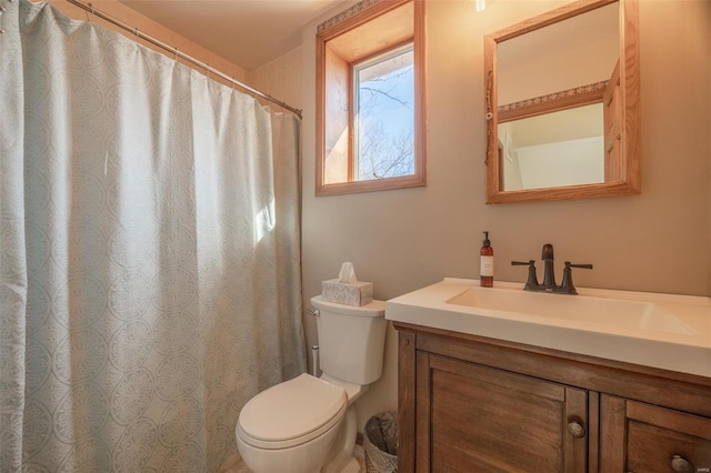 bathroom featuring toilet, vanity, and a shower with curtain
