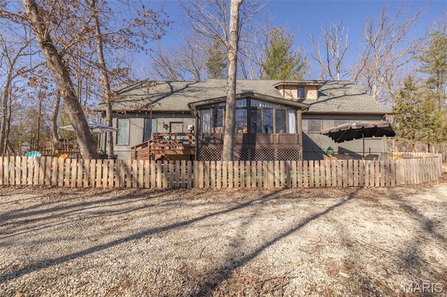 566 Aspen View Dr, Innsbrook, MO 63390 - back of house featuring a fenced front yard, a sunroom, a wooden deck, and roof with shingles