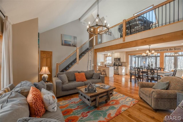 566 Aspen View Dr, Innsbrook, MO 63390 - living area with a chandelier, high vaulted ceiling, light wood finished floors, and stairs