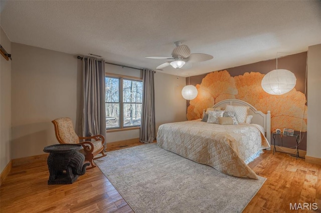 566 Aspen View Dr, Innsbrook, MO 63390 - bedroom with wood finished floors, baseboards, a ceiling fan, and a textured ceiling