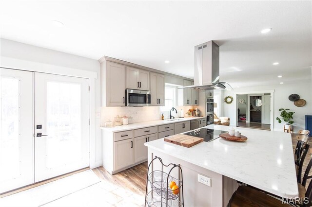 11720 County Road 5160, Rolla, MO 65401 - kitchen with stainless steel appliances, gray cabinets, island exhaust hood, a breakfast bar area, and a sink