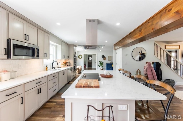 11720 County Road 5160, Rolla, MO 65401 - kitchen with appliances with stainless steel finishes, a sink, island exhaust hood, a kitchen bar, and backsplash