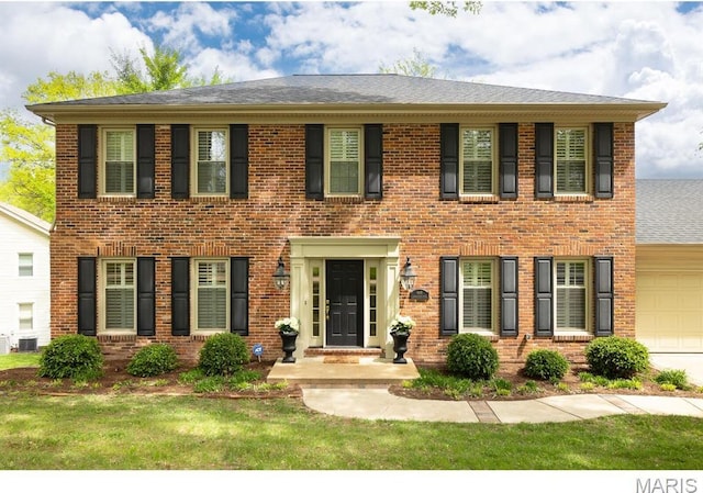 668 Clear Brook Dr, Des Peres, MO 63122 - colonial house featuring brick siding, cooling unit, an attached garage, a front yard, and a shingled roof