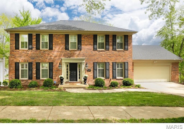 668 Clear Brook Dr, Des Peres, MO 63122 - colonial-style house with a garage, driveway, brick siding, a front yard, and roof with shingles