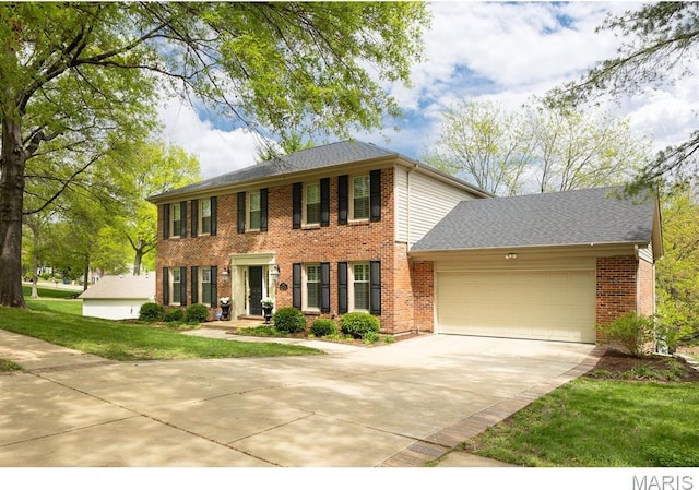 668 Clear Brook Dr, Des Peres, MO 63122 - colonial inspired home with an attached garage, concrete driveway, brick siding, a front yard, and roof with shingles