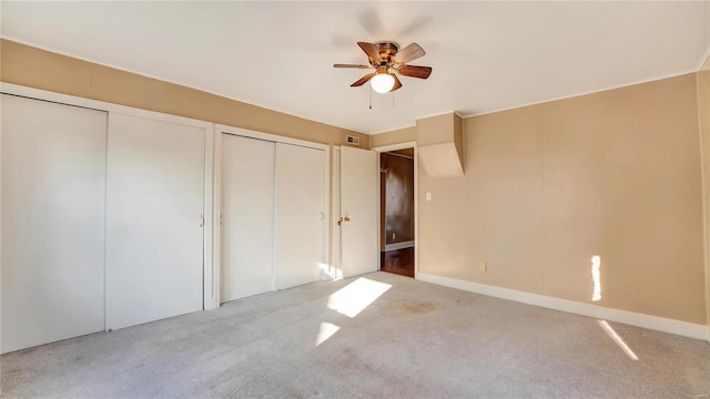 209 W Washington Ave, Richland, MO 65556 - unfurnished bedroom with carpet flooring, multiple closets, a ceiling fan, and baseboards