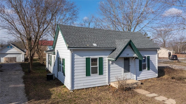 209 W Washington Ave, Richland, MO 65556 - view of front of property featuring a garage, roof with shingles, and cooling unit
