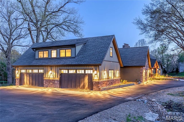 5 Glaizeview Rd, Town And Country, MO 63017 - view of front facade with driveway, a chimney, a shingled roof, and board and batten siding