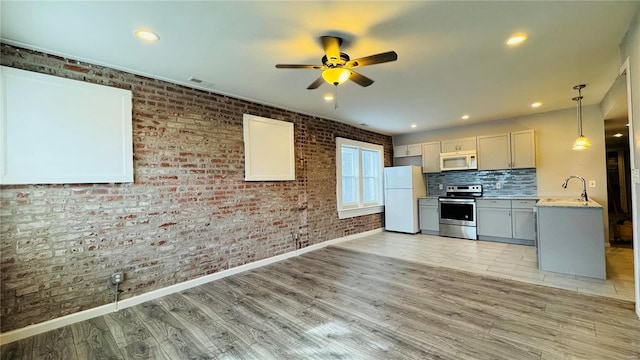 3683 Montana St, Saint Louis, MO 63116 - kitchen featuring white appliances, a ceiling fan, light wood-style floors, a sink, and brick wall