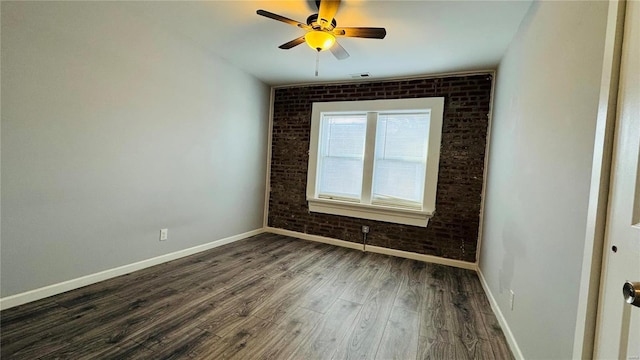 3683 Montana St, Saint Louis, MO 63116 - empty room featuring brick wall, dark wood-style flooring, baseboards, and a ceiling fan